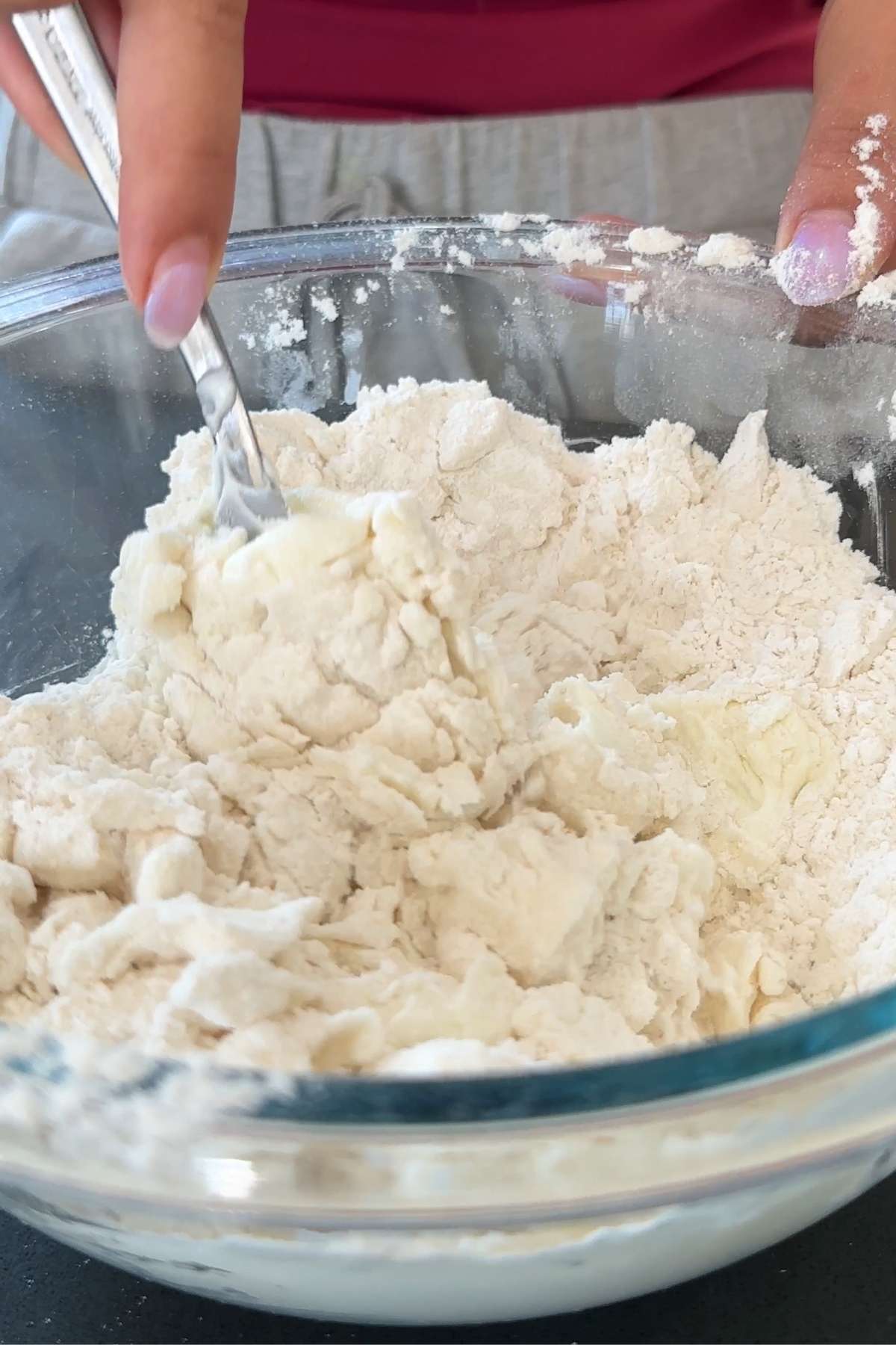 Mixing dough in a glass bowl.