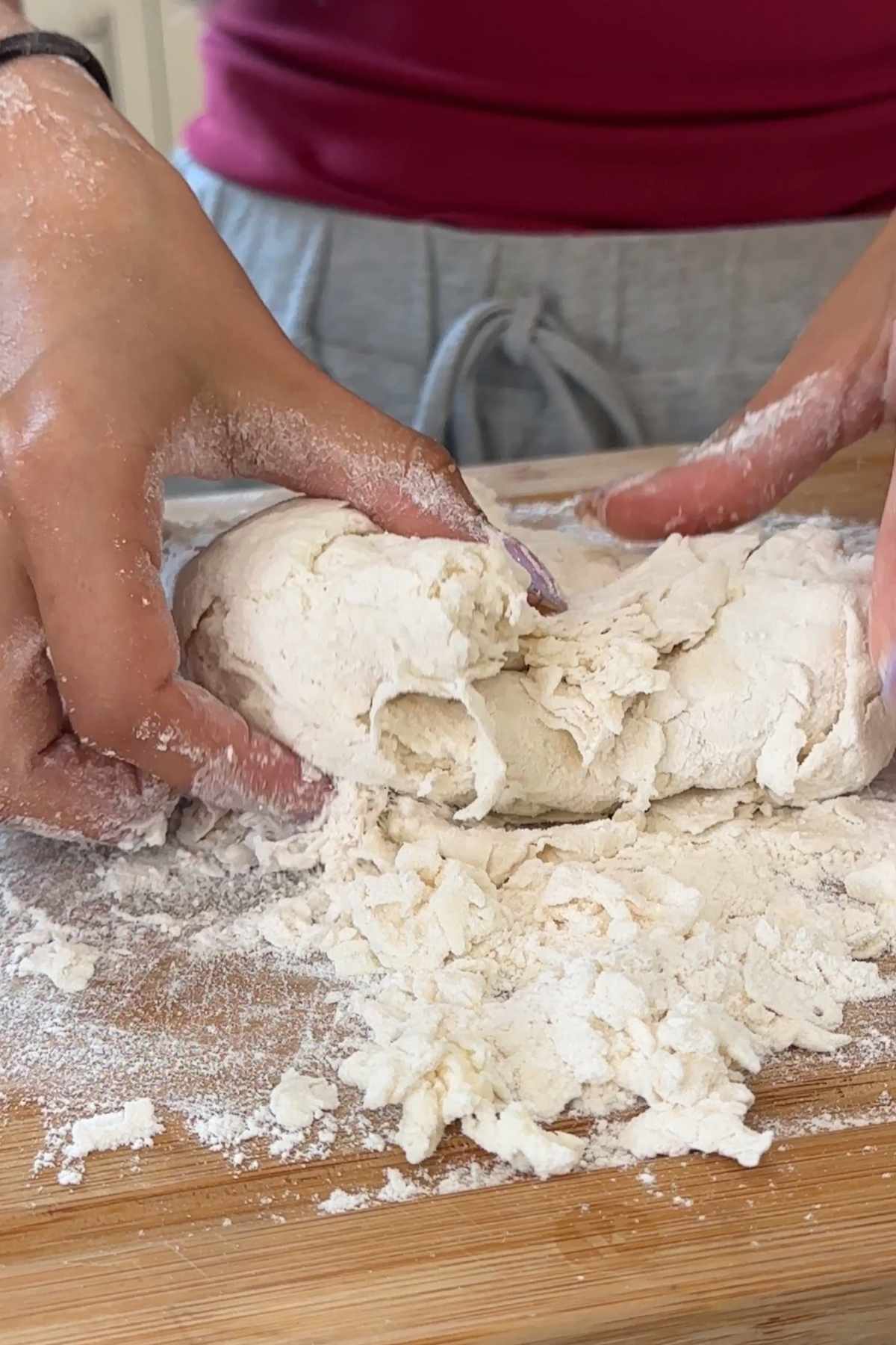 Hands kneading dough for bagels.