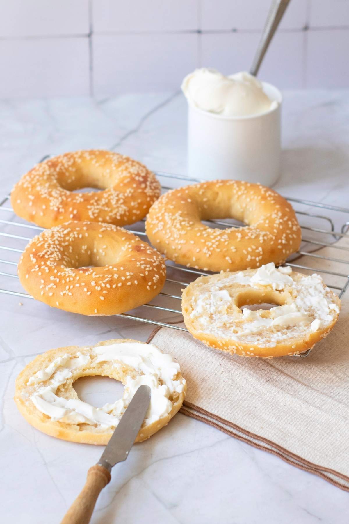 Bagels with cream cheese, one sliced.