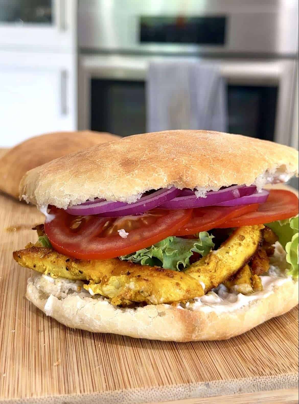 Delicious chicken sandwich on homemade bread with tomato, lettuce, and red onion. Perfect for Crispy Four Ingredient Sandwich Bread!