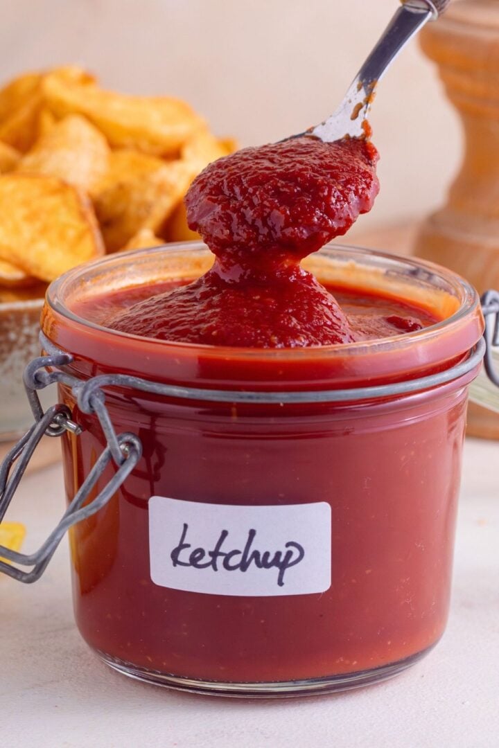 Homemade healthy ketchup in a jar with fries.