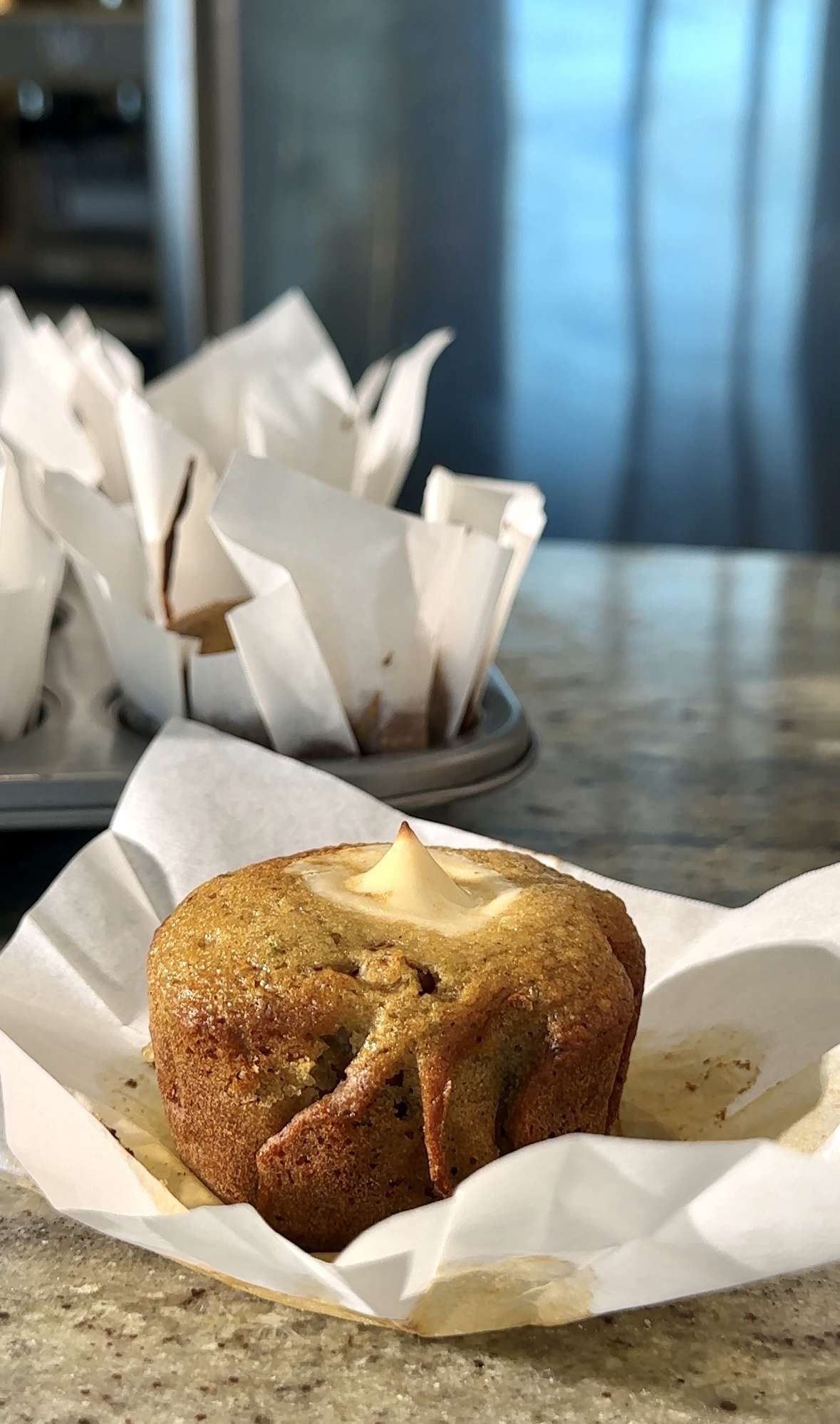 Cream cheese filled pear muffin on parchment paper, fresh from the oven.