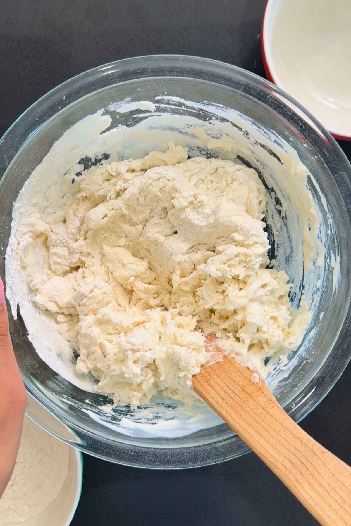 Mixing kefir bread dough in a glass bowl.