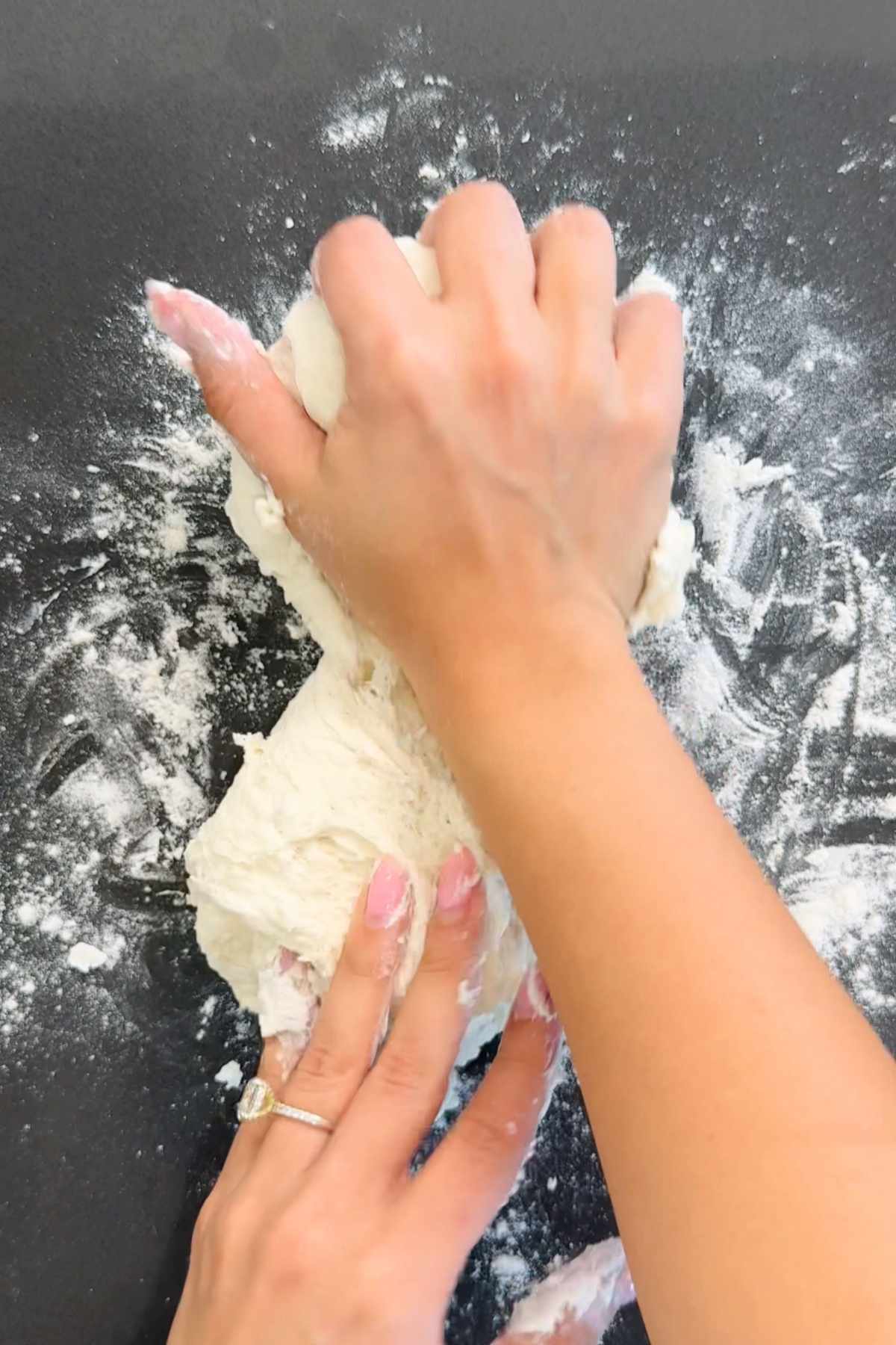 Hands kneading kefir bread dough.