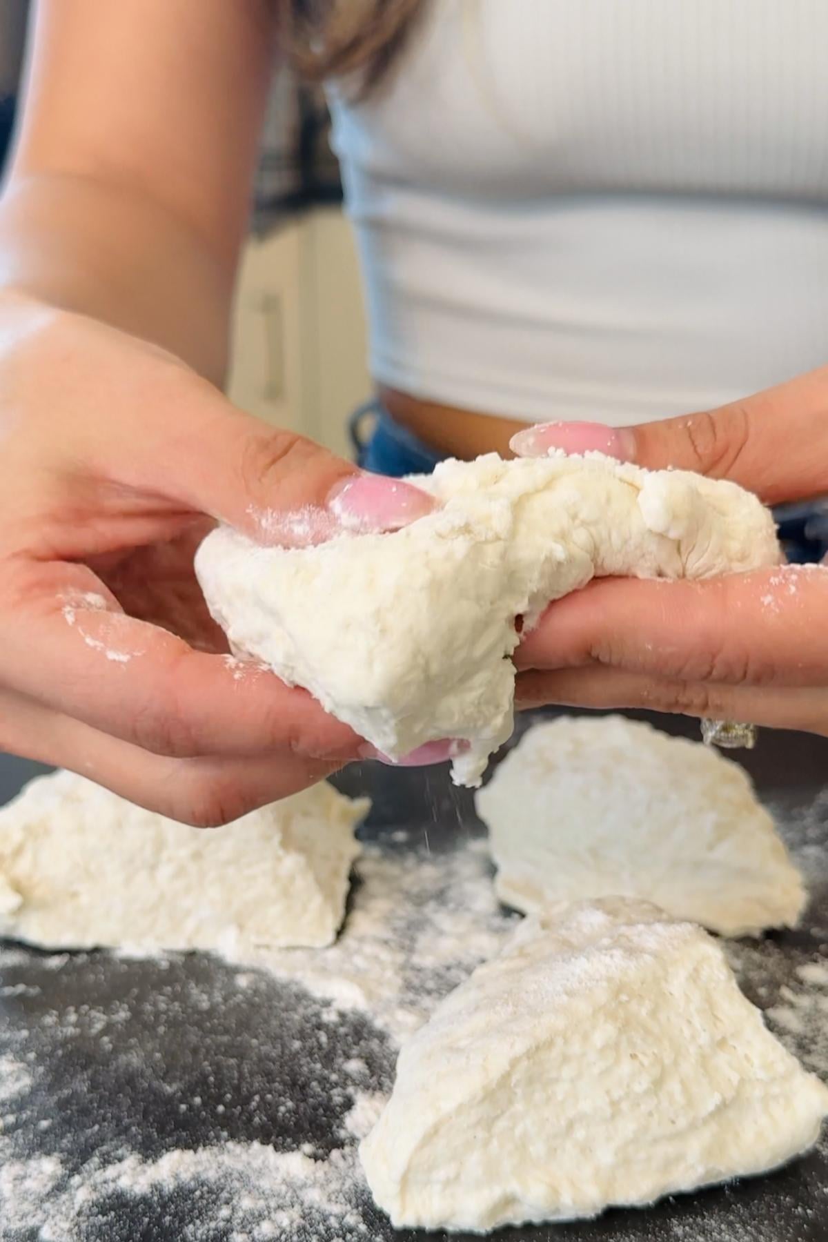 Hands kneading kefir bread dough.