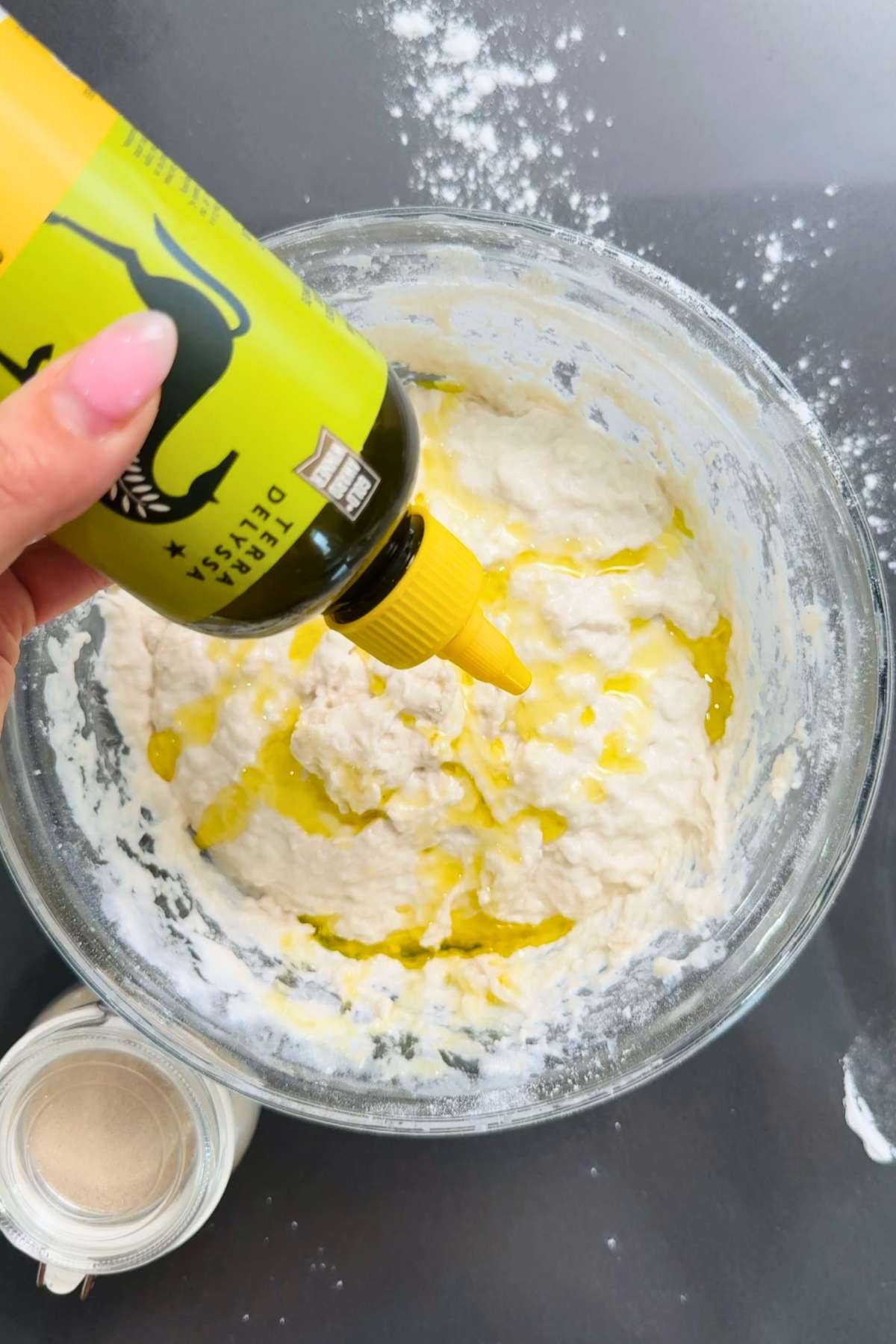 Adding olive oil to pizza dough.