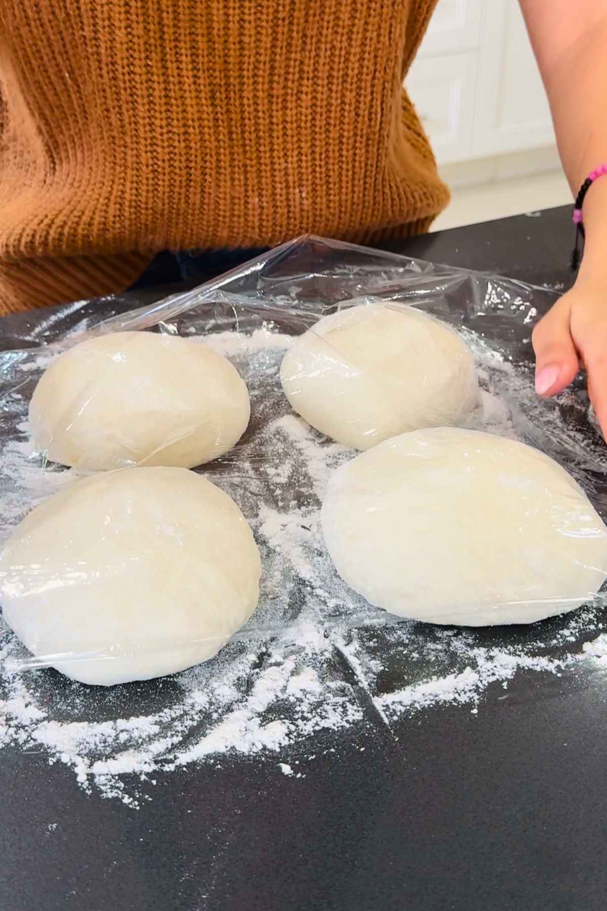Neapolitan pizza dough balls covered in plastic wrap.