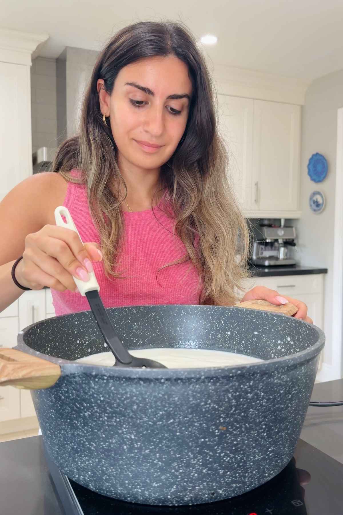 Woman cooking mozzarella in pot