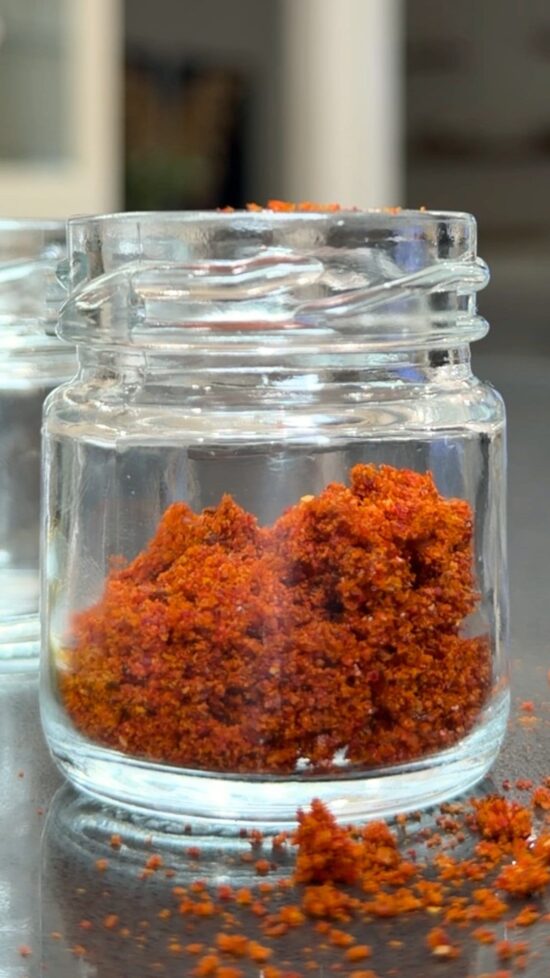 Homemade paprika in a small glass jar. Learn how to make paprika at home.