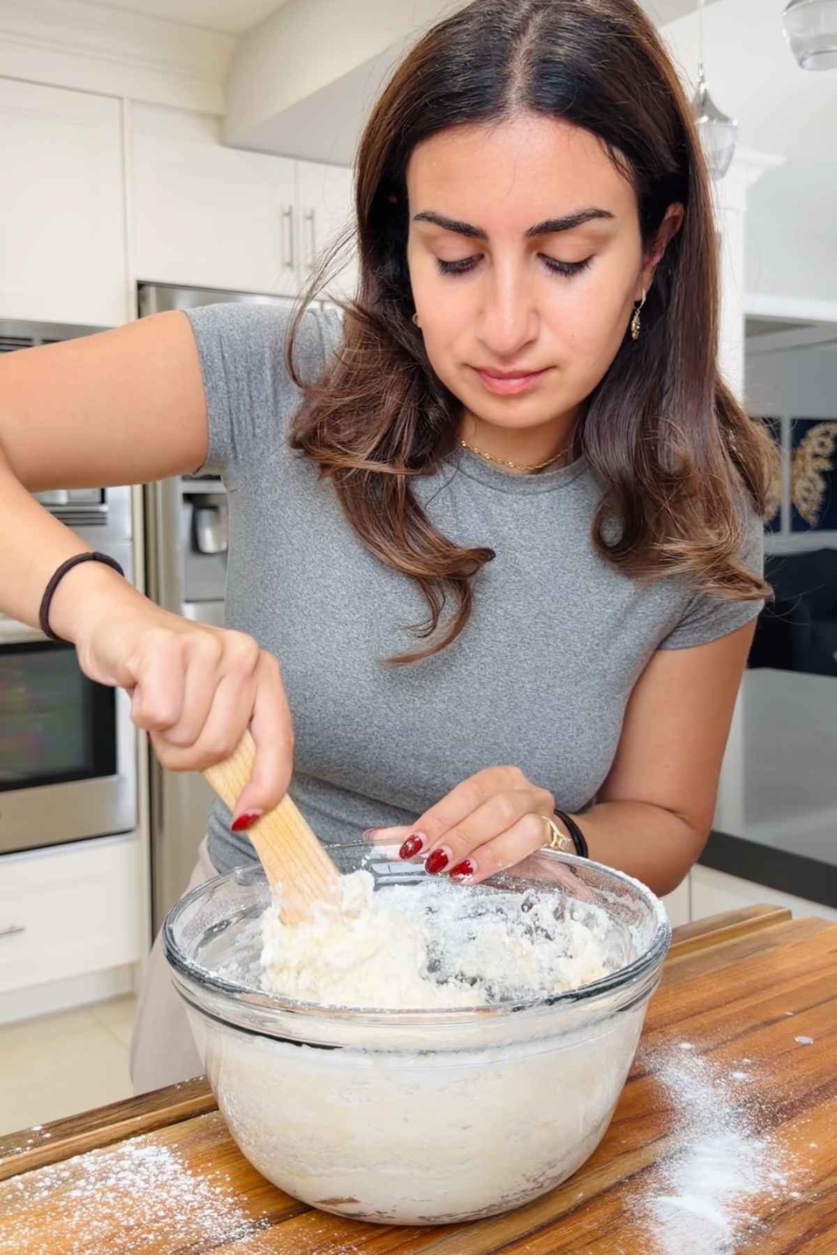Woman mixing dough in a bowl.