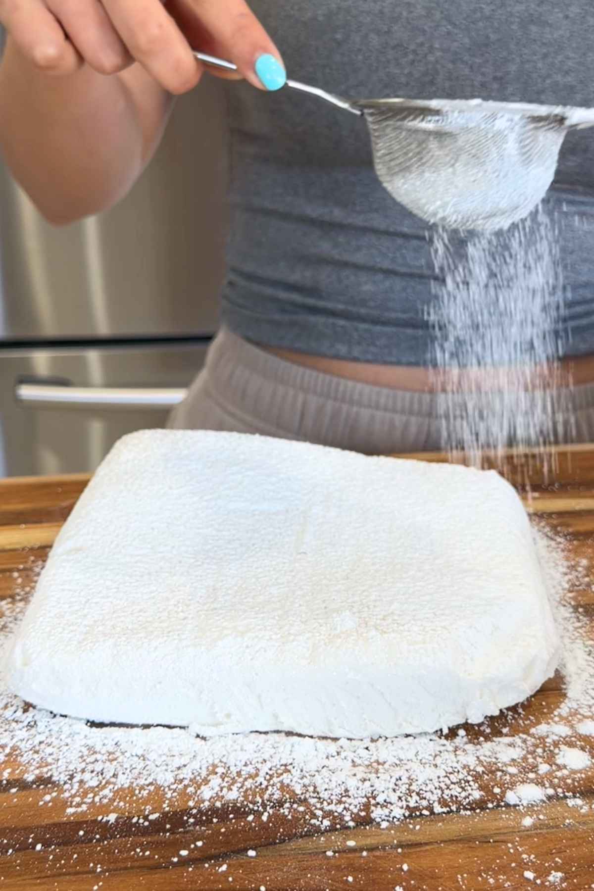 Dusting homemade marshmallow with powdered sugar.