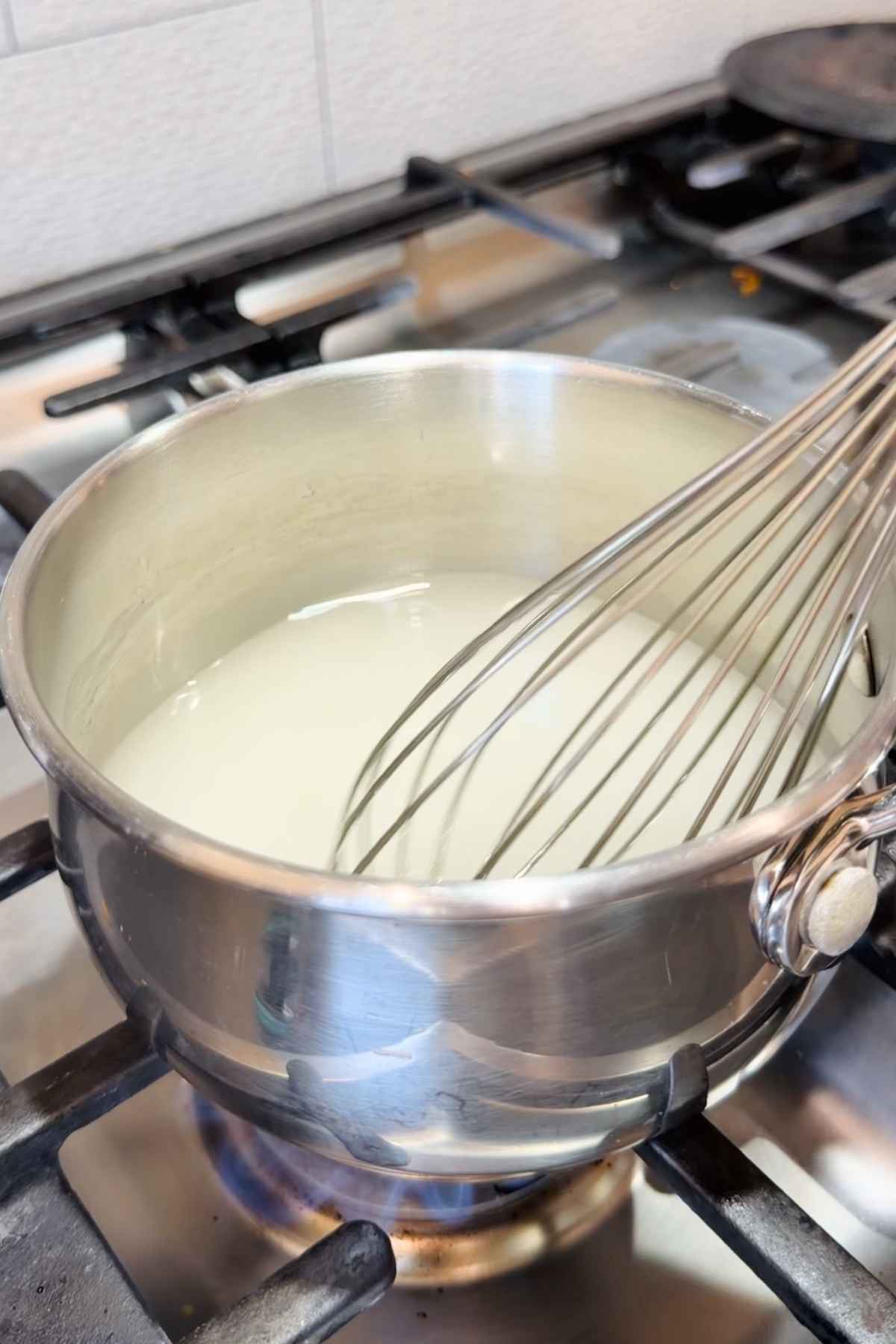 Whisking homemade marshmallow mixture in saucepan.